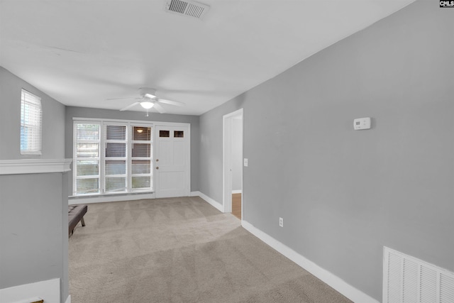 carpeted spare room featuring ceiling fan