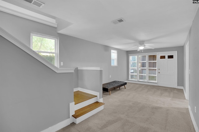 entryway featuring ceiling fan and light carpet