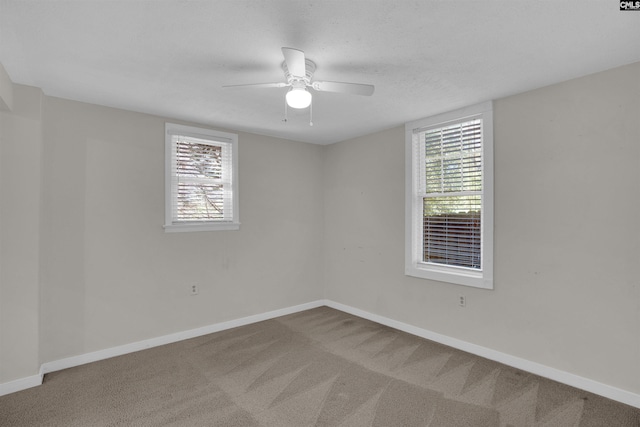 spare room with ceiling fan, carpet, and a healthy amount of sunlight