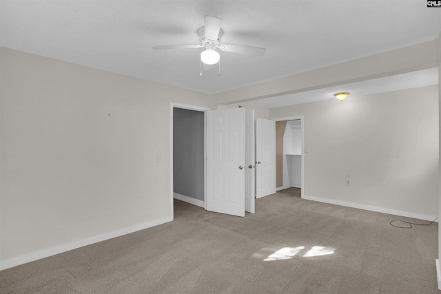 spare room with ceiling fan and light colored carpet