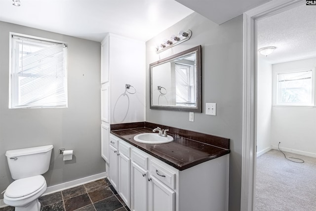 bathroom featuring vanity, toilet, and a wealth of natural light