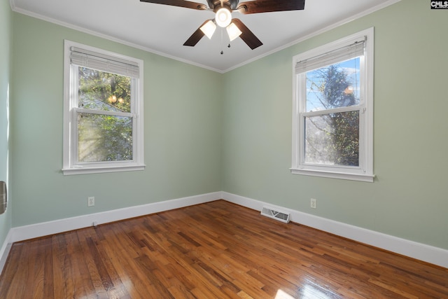 spare room featuring ceiling fan, plenty of natural light, crown molding, and hardwood / wood-style flooring