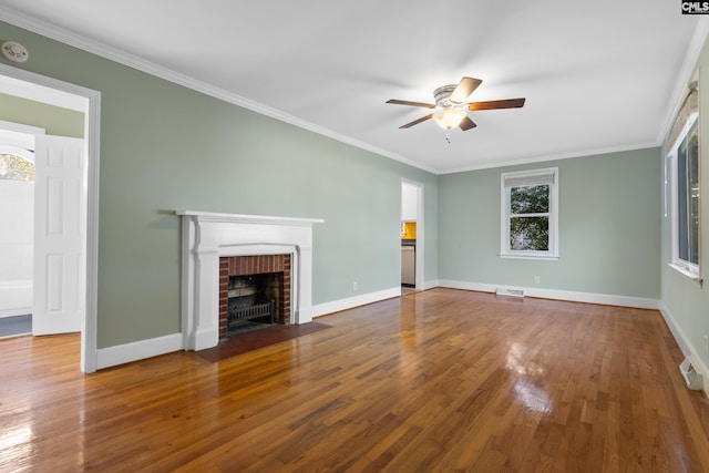 unfurnished living room with hardwood / wood-style flooring, ceiling fan, ornamental molding, and a fireplace