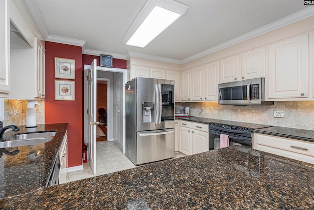 kitchen with backsplash, stainless steel appliances, light tile patterned floors, dark stone countertops, and white cabinetry