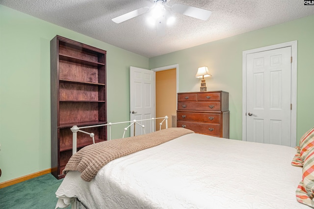 bedroom with ceiling fan, carpet floors, and a textured ceiling