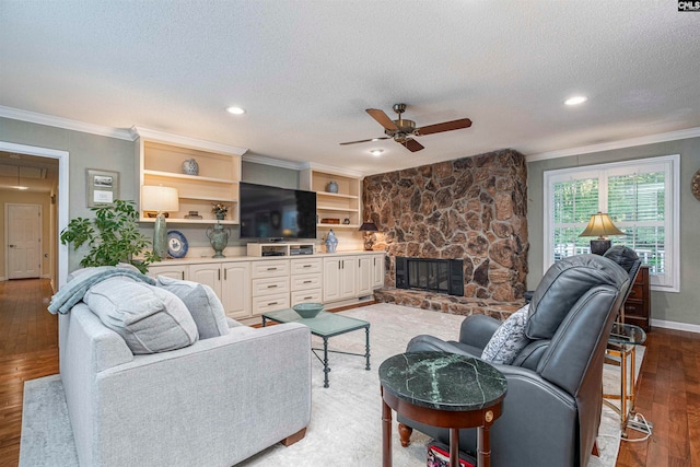 living room featuring a fireplace, built in shelves, a textured ceiling, and light hardwood / wood-style floors