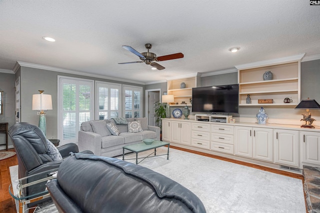 living room with hardwood / wood-style flooring, ceiling fan, crown molding, and a textured ceiling