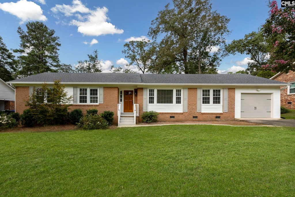 ranch-style house featuring a garage and a front lawn