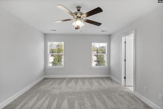 carpeted empty room with plenty of natural light and ceiling fan