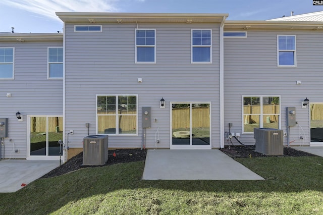 rear view of property featuring a patio area, a yard, and central AC