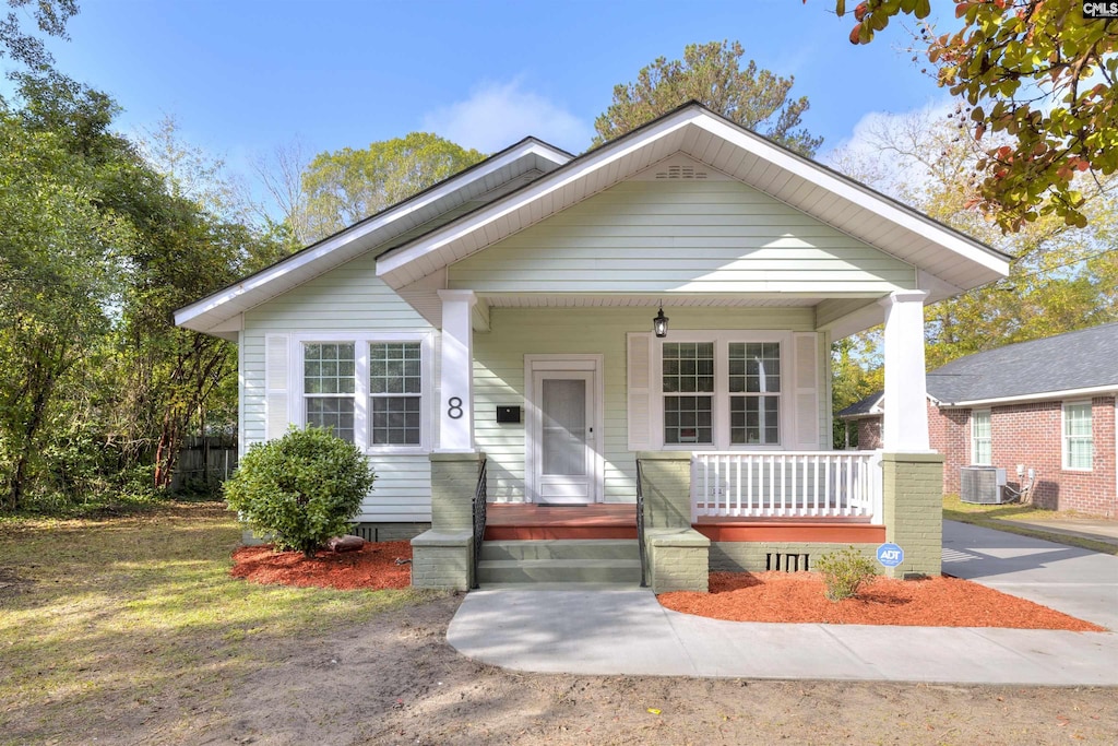 bungalow featuring covered porch and central air condition unit