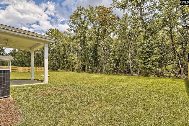 view of yard featuring ceiling fan, a patio area, and central air condition unit