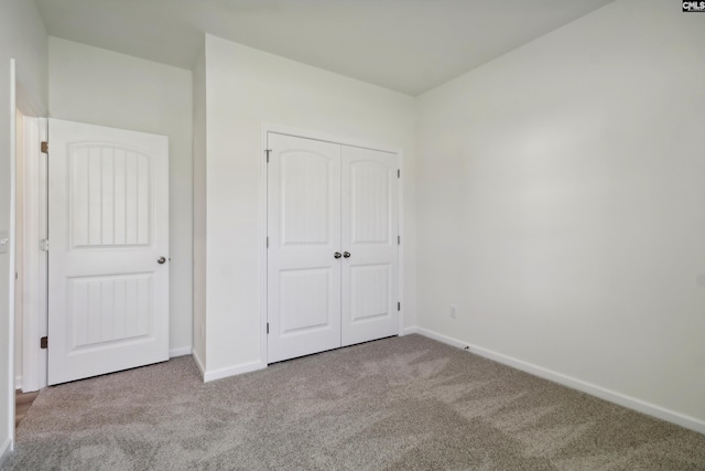 unfurnished bedroom featuring a closet and light colored carpet