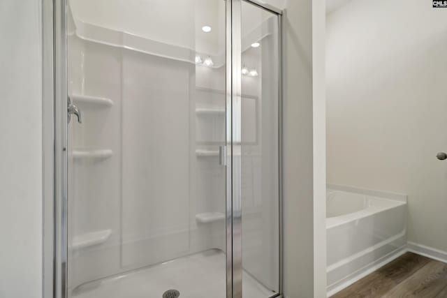 bathroom featuring hardwood / wood-style floors and independent shower and bath