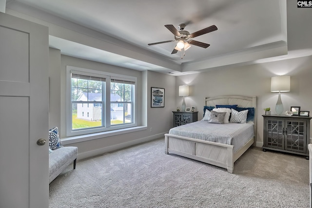 bedroom featuring a raised ceiling, ceiling fan, and carpet