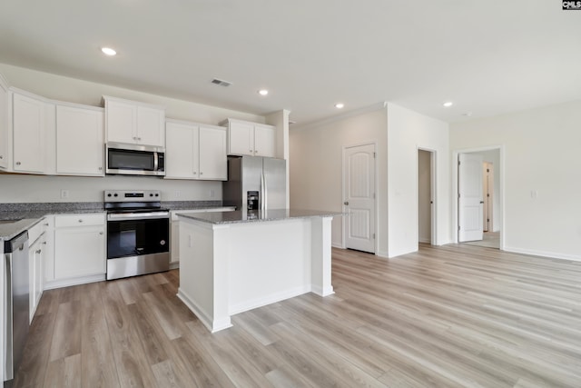 kitchen featuring white cabinetry, a kitchen island, light wood-type flooring, and appliances with stainless steel finishes