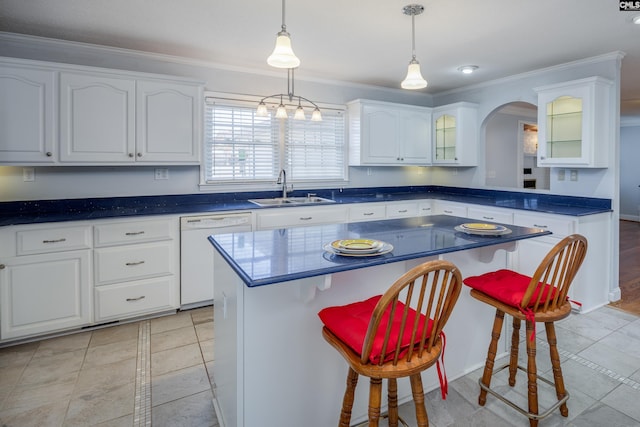 kitchen featuring a breakfast bar, white dishwasher, sink, a center island, and white cabinetry