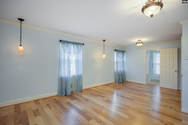 unfurnished room with light hardwood / wood-style flooring, a wealth of natural light, and crown molding