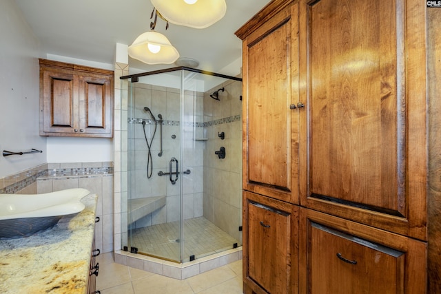 bathroom featuring tile patterned flooring, vanity, tile walls, and walk in shower