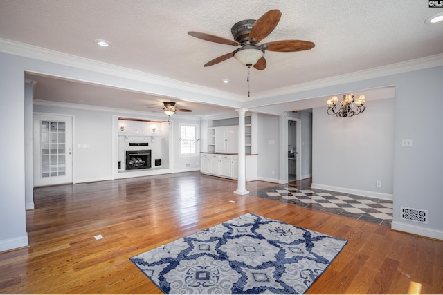 living room featuring ceiling fan with notable chandelier, dark wood-type flooring, and a textured ceiling