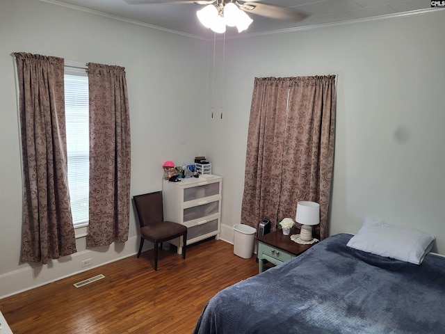 bedroom featuring ornamental molding, ceiling fan, and dark wood-type flooring