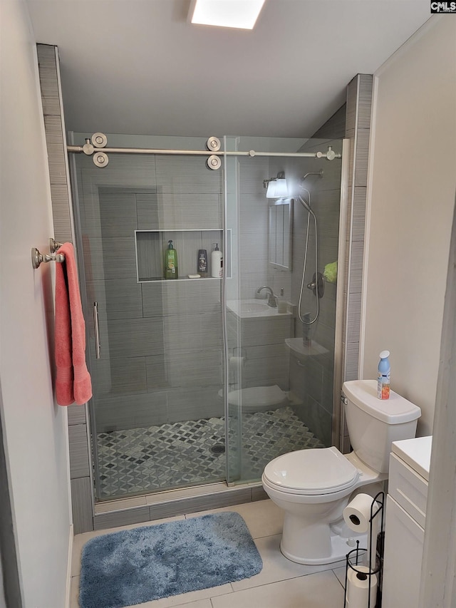 bathroom featuring tile patterned flooring, vanity, toilet, and a shower with shower door