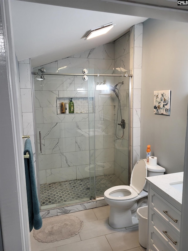 bathroom featuring tile patterned floors, vanity, a shower with door, toilet, and lofted ceiling