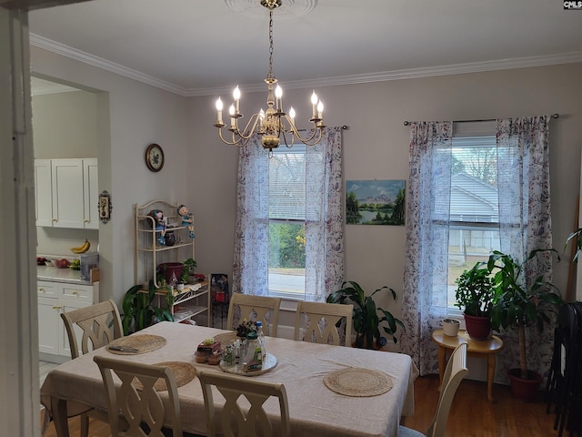 dining space with hardwood / wood-style flooring, an inviting chandelier, a wealth of natural light, and crown molding