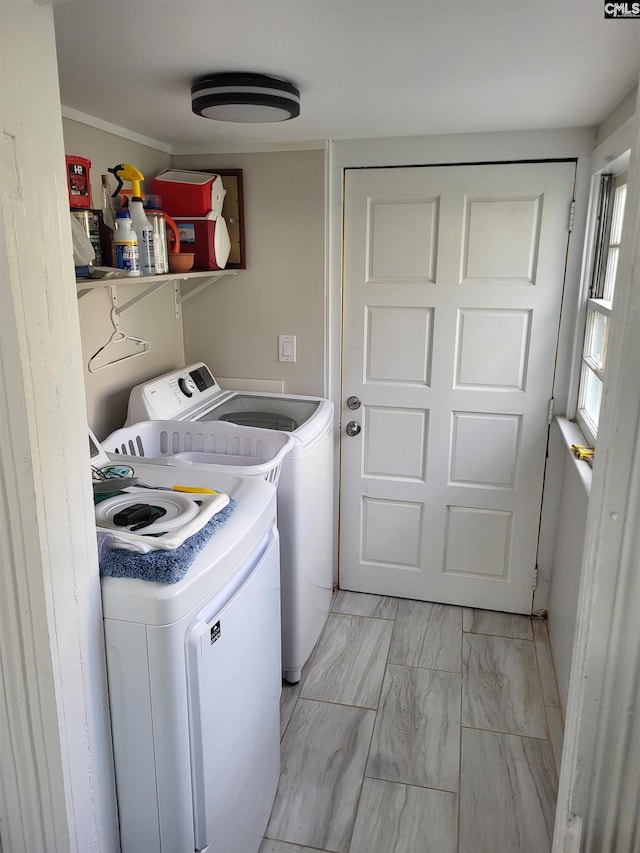 laundry room featuring washing machine and clothes dryer and ornamental molding