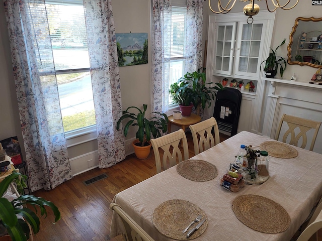 dining room with dark hardwood / wood-style floors and an inviting chandelier