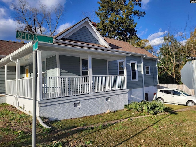 view of front of property with covered porch and a front yard