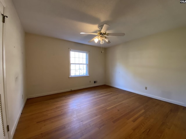 empty room with ceiling fan and wood-type flooring