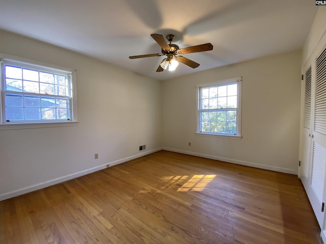 unfurnished bedroom featuring a closet, hardwood / wood-style flooring, and ceiling fan