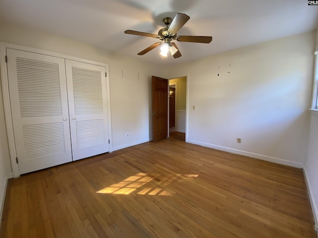 unfurnished bedroom with wood-type flooring, a closet, and ceiling fan