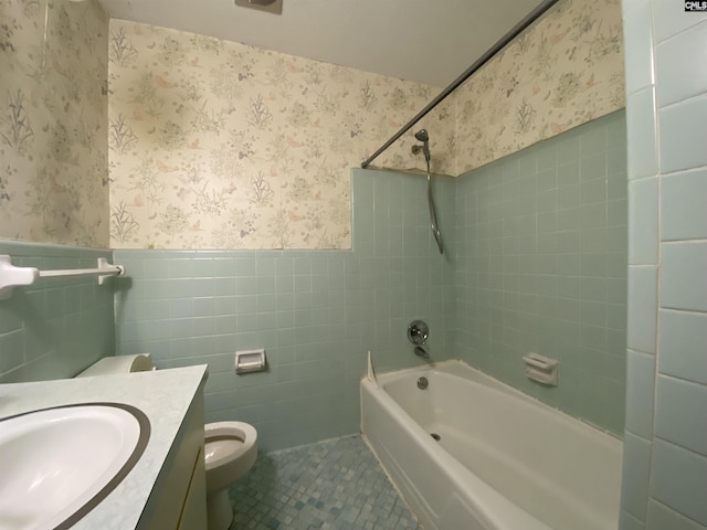 full bathroom featuring vanity, tile walls, tile patterned flooring, toilet, and tiled shower / bath