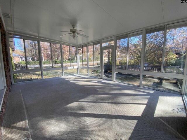 unfurnished sunroom with ceiling fan and a healthy amount of sunlight