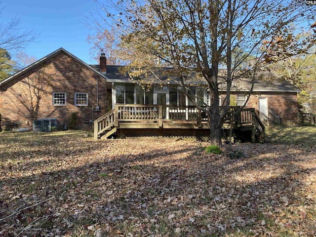 rear view of house with a sunroom, central air condition unit, and a wooden deck