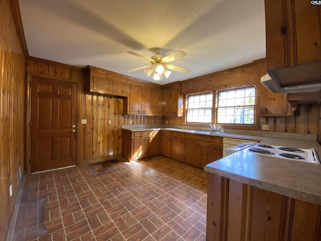 kitchen with wood walls, white stovetop, ceiling fan, a textured ceiling, and kitchen peninsula