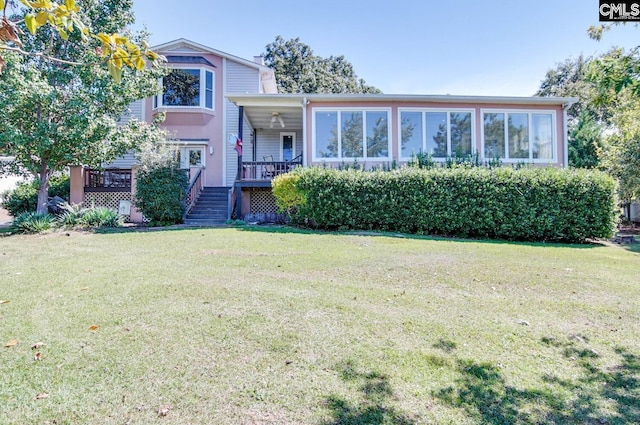 view of front facade featuring a sunroom and a front lawn