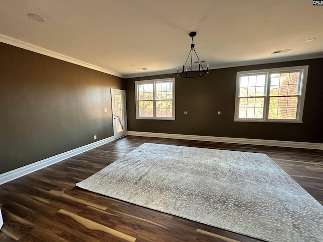 unfurnished room with dark hardwood / wood-style flooring, plenty of natural light, ornamental molding, and a notable chandelier