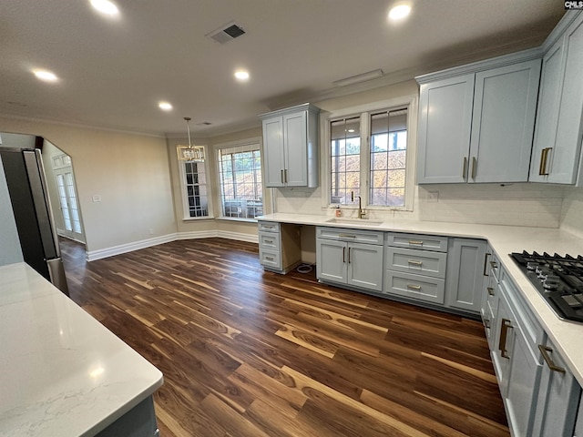 kitchen featuring gray cabinetry, stainless steel fridge, dark hardwood / wood-style flooring, and black gas stovetop