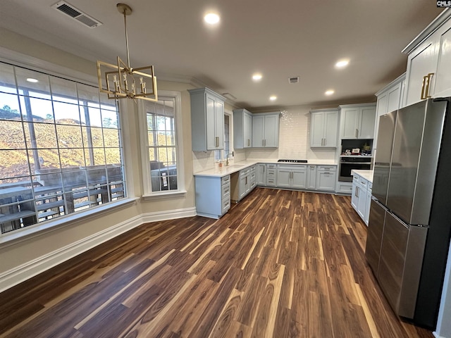 kitchen featuring an inviting chandelier, dark hardwood / wood-style floors, gray cabinets, decorative light fixtures, and stainless steel appliances