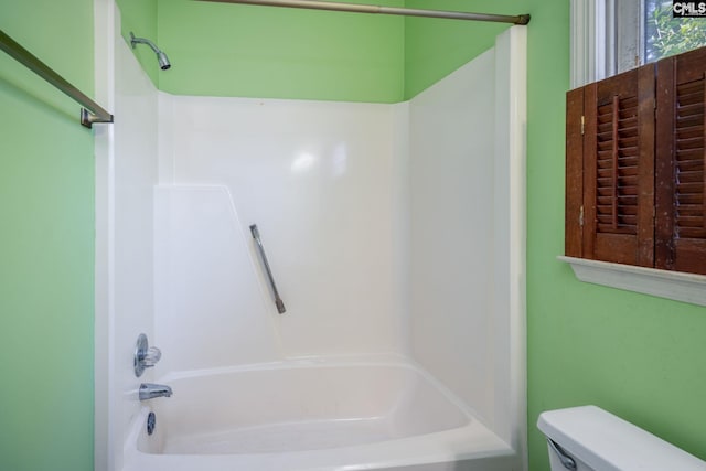 bathroom featuring shower / bath combination and toilet