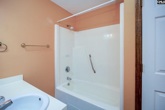 bathroom with  shower combination, vanity, and a textured ceiling