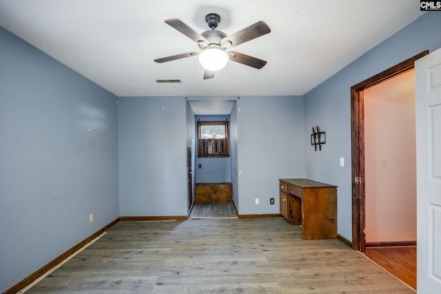 unfurnished room with ceiling fan, light hardwood / wood-style floors, and a textured ceiling