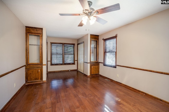 empty room featuring dark hardwood / wood-style flooring and ceiling fan