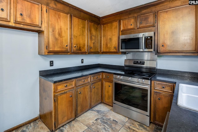 kitchen with sink, stainless steel appliances, and a textured ceiling