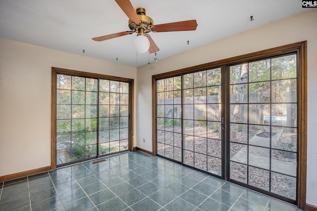 spare room featuring ceiling fan, a healthy amount of sunlight, and a textured ceiling