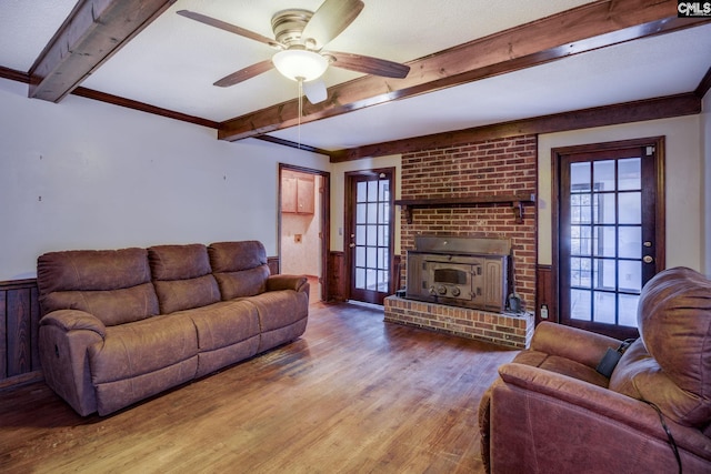 living room with beam ceiling, ceiling fan, a brick fireplace, a textured ceiling, and hardwood / wood-style flooring