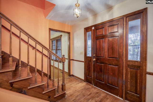 entrance foyer with light hardwood / wood-style floors and a textured ceiling